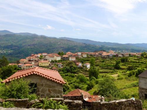un villaggio su una collina con le montagne sullo sfondo di Casa da iapa a Soajo