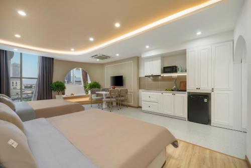 a large kitchen and living room with white cabinets at Q Apartment Da Nang in Da Nang