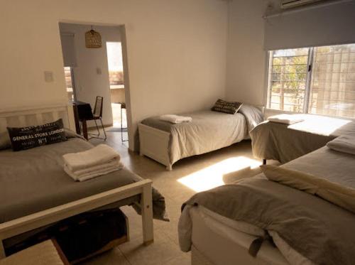 a bedroom with three beds and a window at vivestadias in San Gregorio