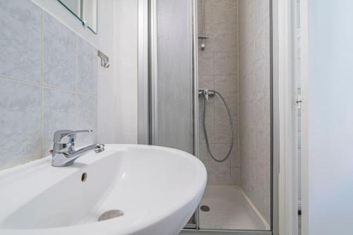 une salle de bain blanche avec un lavabo et une douche dans l'établissement Saint Rémi 522, à Reims
