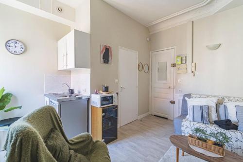 un salon avec un canapé et une cuisine dans l'établissement Saint Rémi 522, à Reims