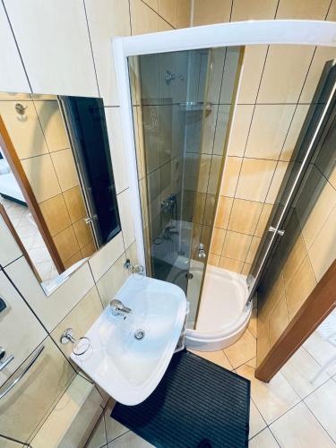 a bathroom with a white sink and a shower at Noclegi u Zygmunta in Mielno