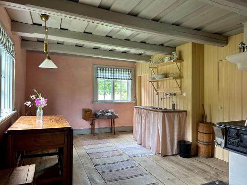 una cucina con tavolo al centro di una stanza di Heritage-listed country cottages a Eskilstuna