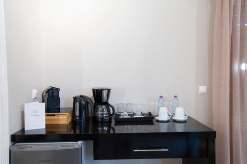 a room with a black counter with a coffee maker and glasses at Athina résidence in Nydri