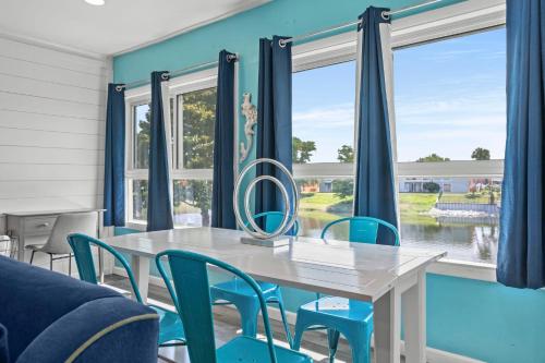 a dining room with a white table and blue chairs at Tranquil Tortuga Lake View Central Destin in Destin