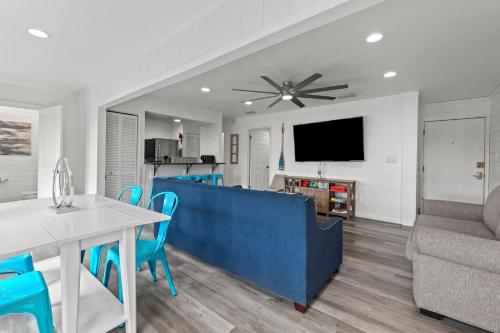 a living room with a blue couch and a table at Tranquil Tortuga Lake View Central Destin in Destin