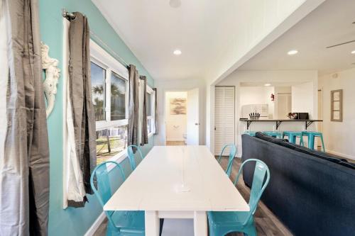 a dining room with a white table and blue chairs at Tranquil Tortuga Lake View Central Destin in Destin