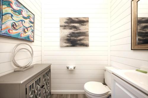 a white bathroom with a toilet and a sink at Tranquil Tortuga Lake View Central Destin in Destin