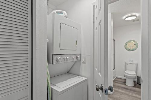 a small bathroom with a toilet and a sink at Tranquil Tortuga Lake View Central Destin in Destin