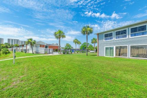 a large yard in front of a building with palm trees at Tranquil Tortuga Lake View Central Destin in Destin