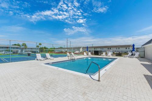 a swimming pool with chairs and a tennis court at Tranquil Tortuga Lake View Central Destin in Destin