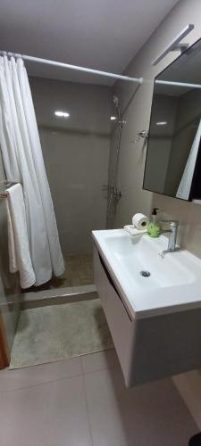a white bathroom with a sink and a mirror at Hotel Viajante in Tarrafal