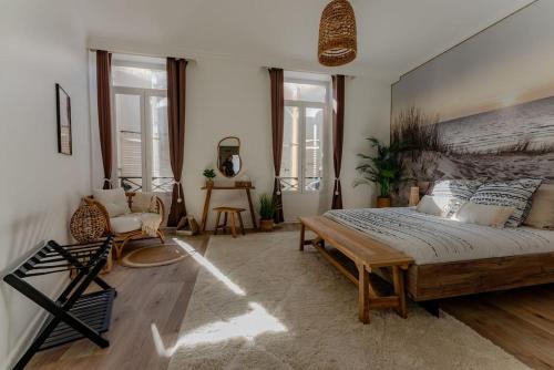 - une chambre avec un grand lit dans une pièce dotée de fenêtres dans l'établissement L'échappée Chic au coeur de Valence, à Valence