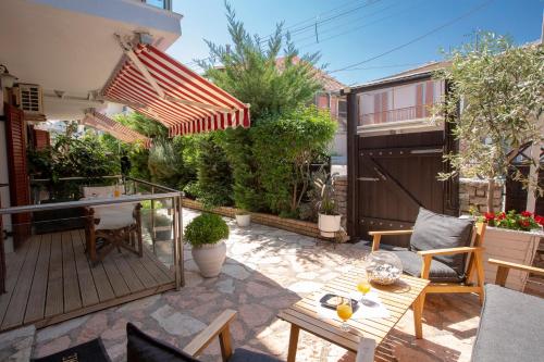 a patio with a table and chairs and an umbrella at Athina résidence in Nydri