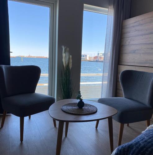 a living room with two chairs and a table and a window at Badholmen Restaurang & Hotell in Oskarshamn