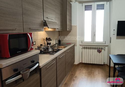 a kitchen with a stove and a sink and a window at Bilocale Moka a Melzo vicino alla stazione e al centro in Melzo