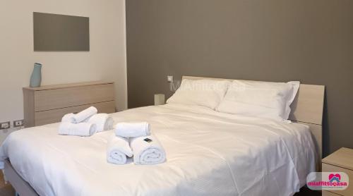 a white bed with towels on top of it at Bilocale Moka a Melzo vicino alla stazione e al centro in Melzo