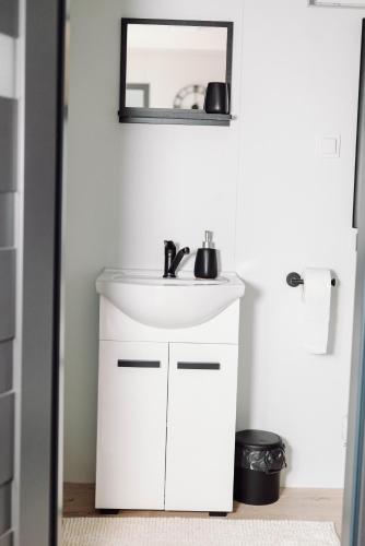 a bathroom with a white sink and a mirror at Domek na Leśnej in Kęty