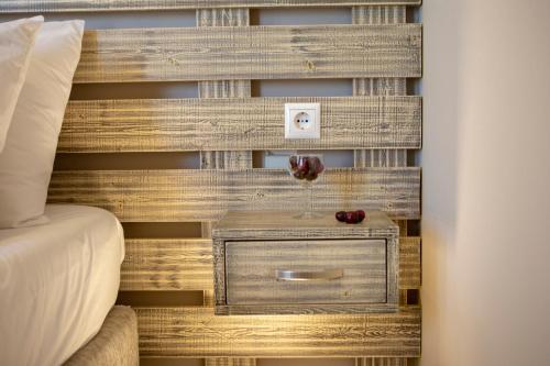 a bed with a wooden headboard with a night stand with a drawer at Athina résidence in Nydri