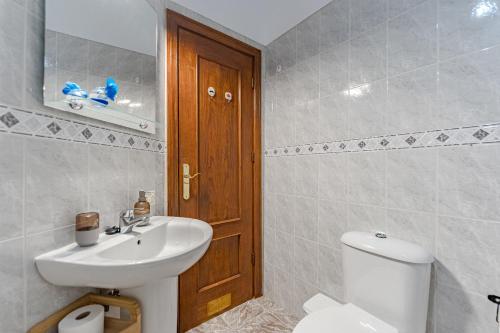 ein Badezimmer mit einem weißen Waschbecken und einer Toilette in der Unterkunft Sea View Apartment Grey Fanta Sea in Arico