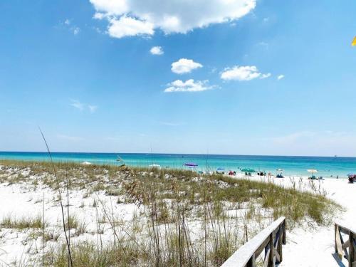 a beach with a bench and the ocean in the background at Bikini Bottom Destin Harbor Private Gated Beach in Destin