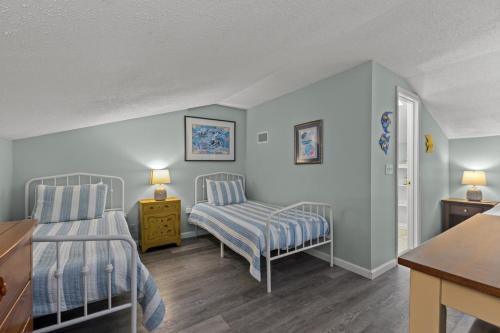 a room with two beds and a table at SeaCove Steps 2 Priv Beach Backyard Comm Pool in Destin