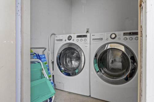 two washing machines in a laundry room with a cart at SeaCove Steps 2 Priv Beach Backyard Comm Pool in Destin
