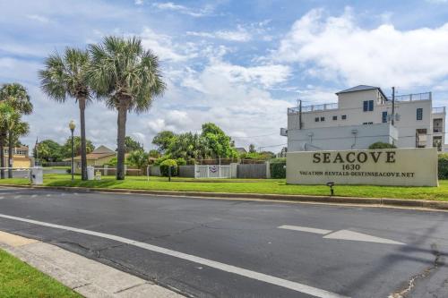 a street in front of a building with a sign at SeaCove Steps 2 Priv Beach Backyard Comm Pool in Destin
