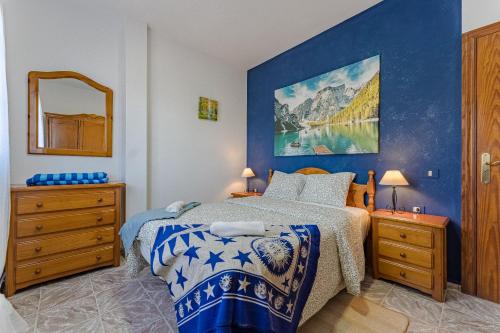 ein Schlafzimmer mit einem Bett und einem Gemälde an der Wand in der Unterkunft Sea View Apartment Blue Pearl in Arico