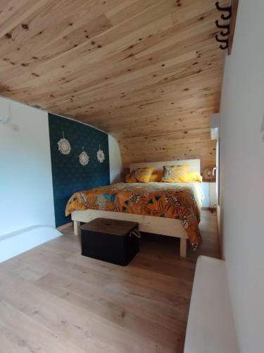 a bedroom with a bed with a wooden ceiling at la carav'âne in Melay-sur-Loire
