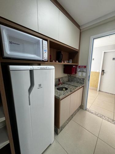 una cocina con un microondas encima de un refrigerador en Borges Locaçoes, en Caldas Novas