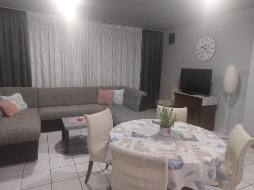 a living room with a couch and a table with chairs at Sandra Apartmani 2 in Zaostrog