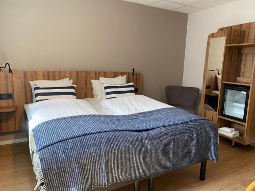 a bedroom with a large bed with blue and white sheets at Badholmen Restaurang & Hotell in Oskarshamn