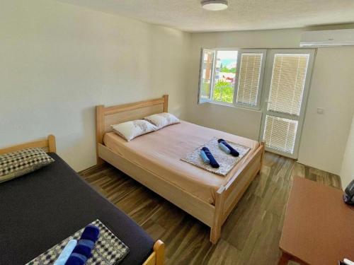 a small bedroom with two beds and a window at KAP Apartments in Sutomore