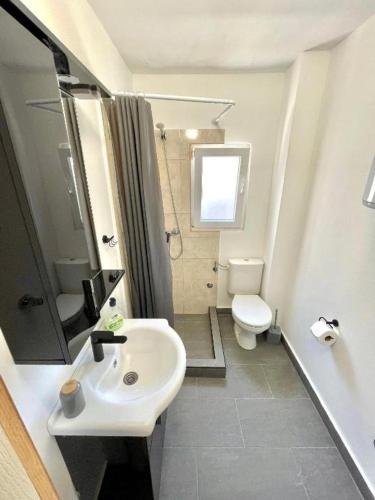 a bathroom with a white sink and a toilet at KAP Apartments in Sutomore