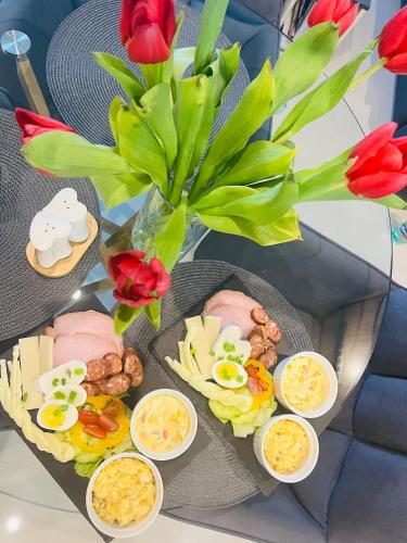 a table topped with plates of food and flowers at Vila LEMAR wellness & spa in Huncovce