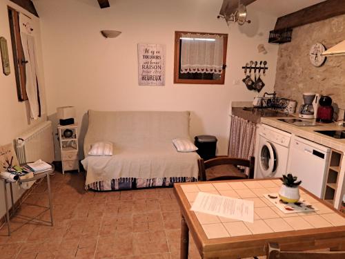 a room with a bed and a kitchen with a table at Le cabanon in Fuveau