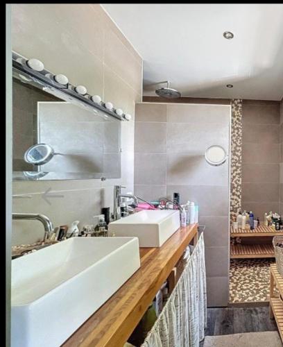 une salle de bain avec un lavabo blanc et un miroir dans l'établissement villa familiale cosy, à Clermont-lʼHérault