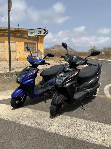two scooters parked on the side of a road at Hotel Viajante in Tarrafal