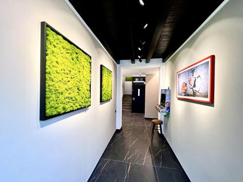 a hallway with green paintings on the walls at CINQUE TERRE Hub Suite ART in La Spezia