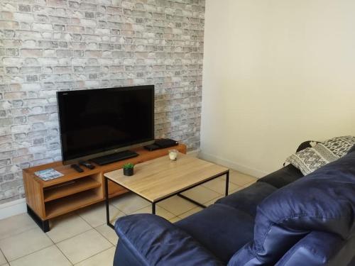 a living room with a couch and a flat screen tv at Gîte le Vieux Moulin in Sansais