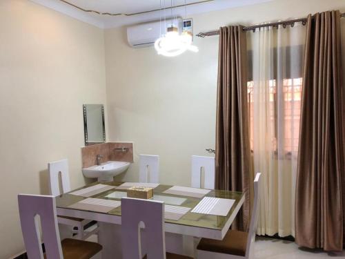 a dining room with a table and a sink at Jengel Double bedroom Furnished Apartment in Entebbe