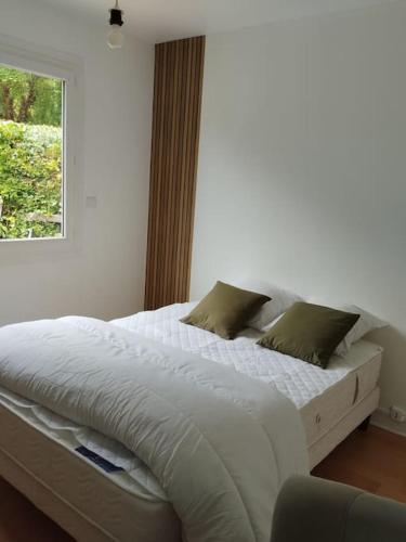 a white bed in a bedroom with a window at Gîte le Vieux Moulin in Sansais