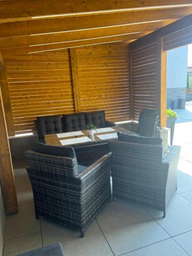 an outdoor patio with wicker chairs and a table at Vila LEMAR wellness & spa in Huncovce