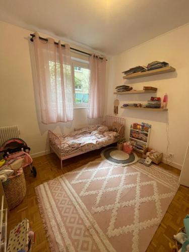 - une chambre pour enfants avec un lit bébé et une fenêtre dans l'établissement Paris Champs-Elysées Flat, à Neuilly-sur-Seine