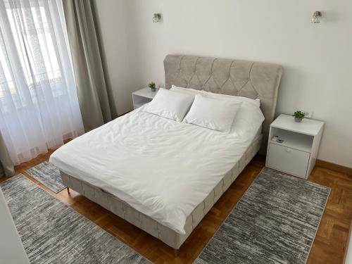 a bed with white sheets and pillows in a bedroom at Sarajevo Luxury Apartment - 50 m from Old Sarajevo Clock Tower in Sarajevo