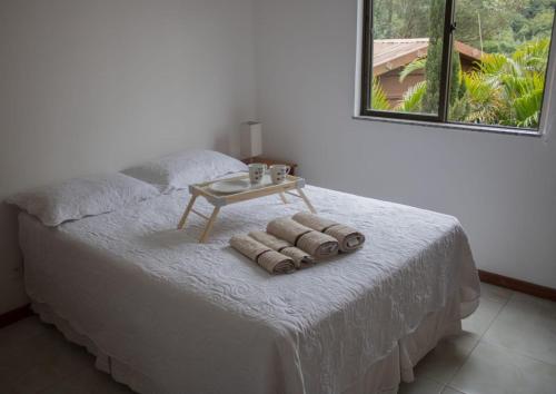 a bedroom with a bed with a table on it at Ecoapê in Petrópolis