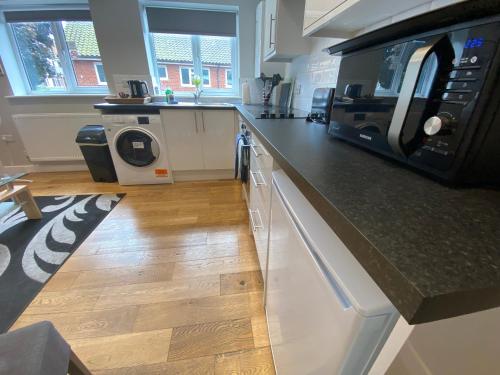 a kitchen with a counter top with a microwave at Vauxhall Apartments in Norwich