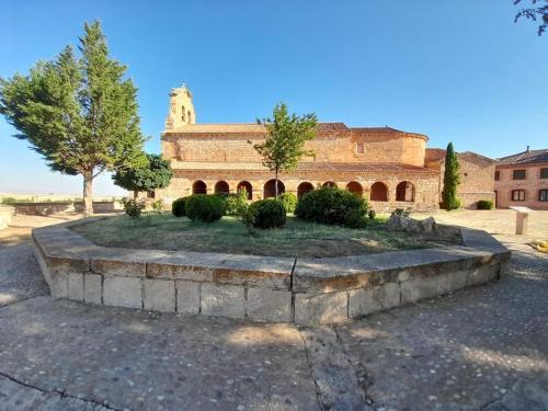 a large brick building with a garden in front of it at Casas Rurales Mi Reja B in Santa María de Riaza