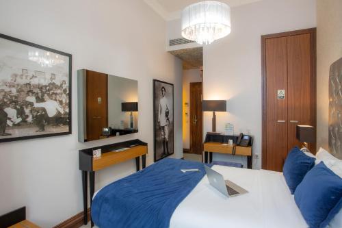 a bedroom with a bed with a laptop on it at Casual Belle Epoque Lisboa in Lisbon